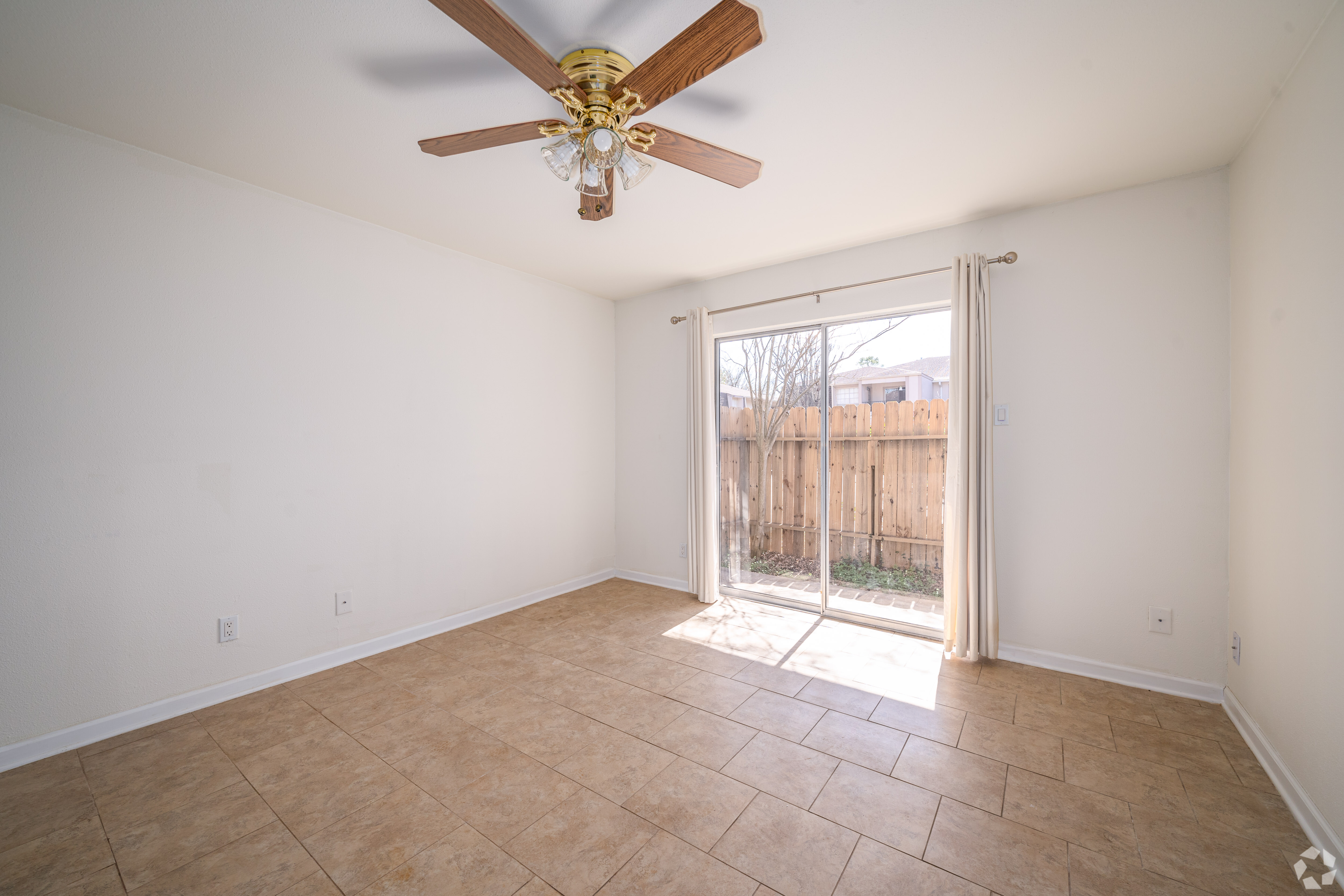 Finished apartment unit interior - bright living room with tile flooring and patio access